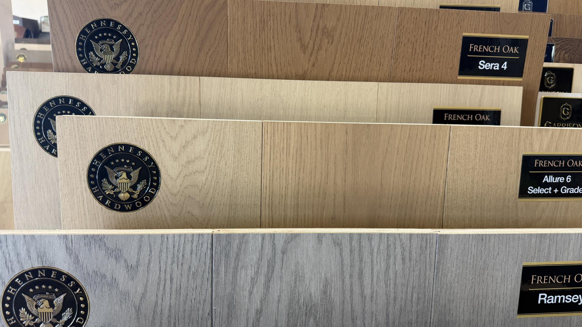 Hennessy Hardwood French Oak planks with brass seals and collection labels at Express Carpet
