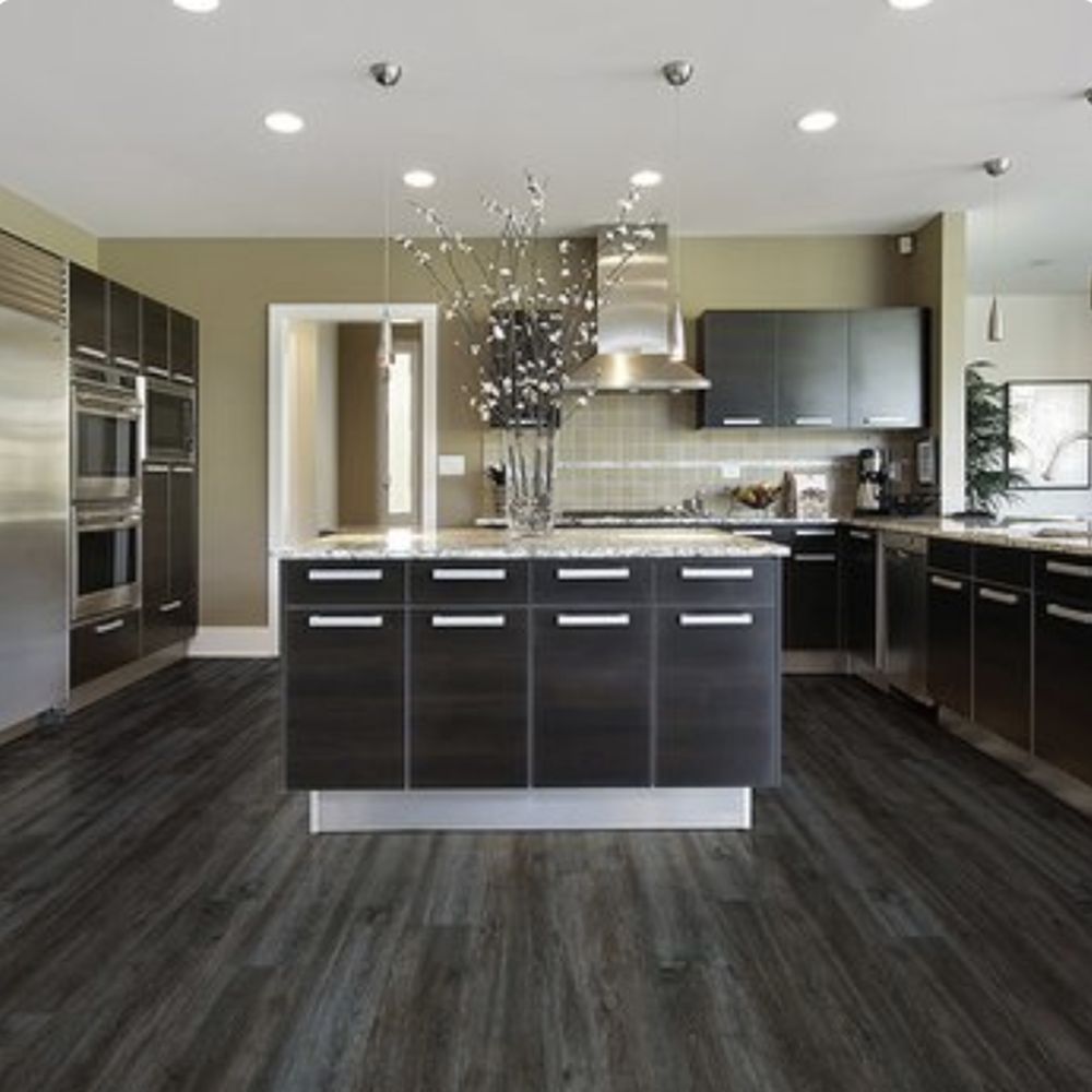 Open kitchen with dark grey wide-plank flooring and a full-height island