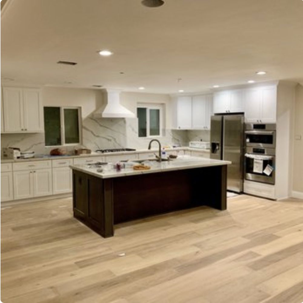 Newly finished kitchen with light oak flooring running through to the island